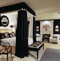 a bedroom with black and white decor, including a four poster bed in the center