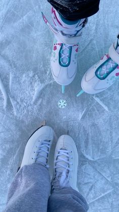 someone is standing on ice with their feet in the air and wearing sneakers that are decorated with snowflakes