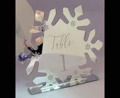 a snowflake table number is displayed in front of a purple background