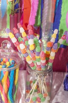 a table topped with lots of candy covered jars