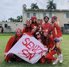 a group of people dressed in red posing for a photo with a flag and some writing on it