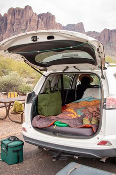 the back end of a car with an open trunk and sleeping bag in it's trunk