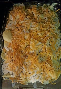 a casserole dish with cheese and other toppings in it on a baking sheet