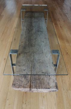 a glass and wood coffee table sitting on top of a hard wood floor in an empty room