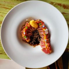 a white plate topped with food on top of a wooden table