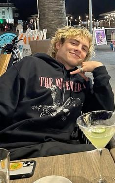 a man sitting at a table with a drink