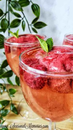 three glasses filled with ice cream and raspberry sorbet on a table