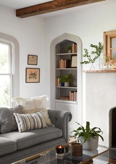 a living room with a couch, coffee table and bookshelf next to a fireplace