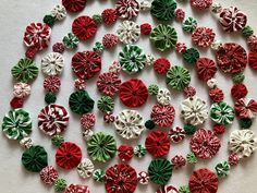 a group of red and green buttons on a white surface with candy canes in the middle