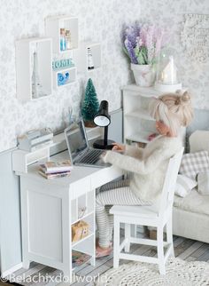 a doll sitting at a desk with a laptop