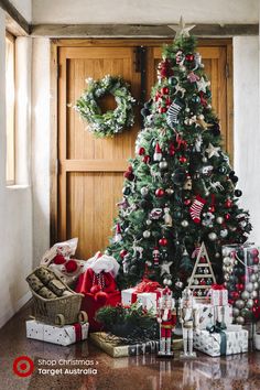 a decorated christmas tree in front of a wooden door