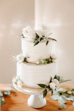 a wedding cake with white flowers and greenery