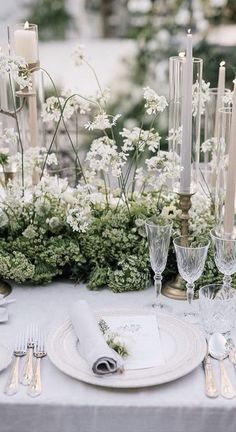 the table is set with white flowers and candles