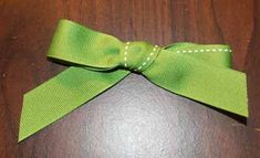 a green bow on top of a wooden table