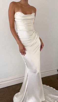 a woman in a white dress posing for the camera