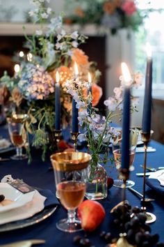 the table is set with blue linens and flowers in vases, candles, and plates