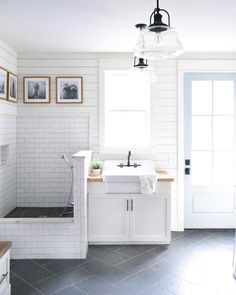 a white bathroom with black and white tile flooring