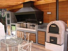 an outdoor kitchen with a pizza oven and dining table