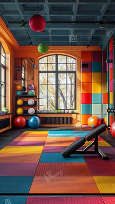 an indoor gym with colorful tiles and exercise balls on the floor in front of a large window