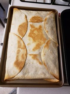 some tortillas are sitting in a pan on top of the stove and ready to be cooked