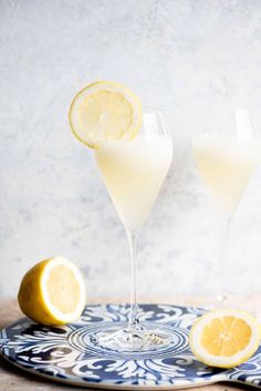 two glasses filled with lemonade sitting on top of a blue and white platter