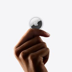 a hand holding an apple logo in front of a white background