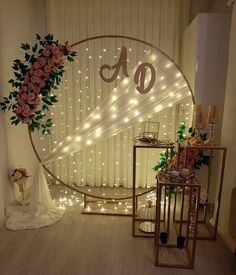 a room decorated with lights and flowers on the wall next to a large round mirror