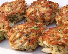 several crab cakes are arranged on a white plate