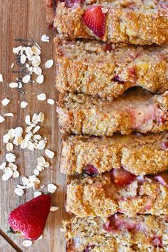 sliced strawberries and oatmeal granola bars on a wooden cutting board