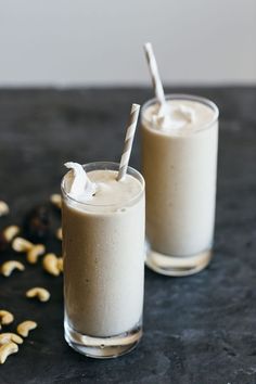 two glasses filled with milk and nuts on a table