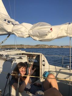 two women sitting on the back of a boat waving