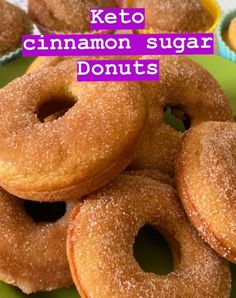 a pile of sugar donuts sitting on top of a green plate