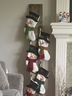 a group of snowmen hanging from the side of a wall next to a fireplace