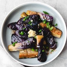 a white plate topped with eggplant and bread