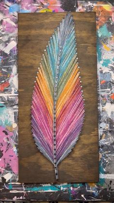 a colorful leaf is painted on a piece of wood