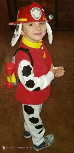 a little boy dressed in a fireman costume