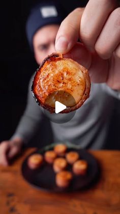 a man is holding up some food to the camera