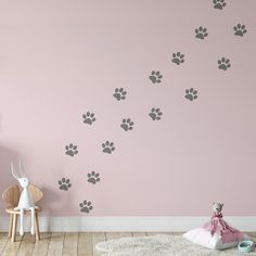 a room with a pink wall and dog paw prints on the wall