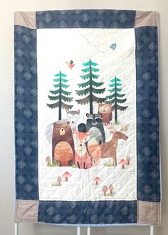 a quilted wall hanging with animals and trees