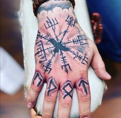 a person's hand with tattoos on it and arrows painted on the palm area