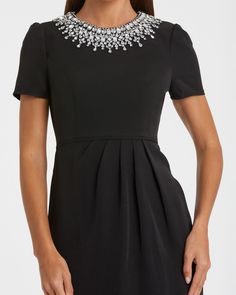 Faites une déclaration avec notre robe colonne à décolleté en strass, dotée d'un superbe col orné à la main composé de perles et de strass incrustés. Ce détail accrocheur ajoute du glamour et de la sophistication à votre look. Avec une découpe chic dans le dos, cette robe est parfaite pour celles qui veulent faire tourner les têtes lors de toute occasion spéciale.



 Mac Duggal

 Tissu crêpe (100% polyester)

 Entièrement doublé sur tout le corps

 Encolure haute




 Manche courte

 Collier embelli à la main composé de perles et de strass incrustés

 Découpe dos

 Fermeture éclair dissimulée au dos

 Environ. 48" du haut de l'épaule à l'ourlet inférieur

 Disponible en Noir



 Modèle #49606 Elegant Embellished Mini Dress For Formal Occasions, Embellished Luxury Mini Dress For Formal Occasions, Luxury Embellished Mini Dress For Formal Occasions, Elegant Formal Mini Dress With Rhinestones, Elegant Embellished Mini Dress For Cocktail, Elegant Crystal Embellished Mini Dress For Night Out, Formal Dresses With Embellished Collar, Elegant Formal Dresses With Embellished Collar, Elegant Party Dress With Embellished Collar