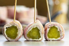 three appetizers with green toppings on sticks