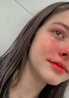 a woman with brown hair is looking at the camera and has her face covered in water