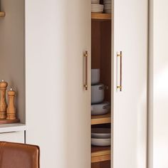 an open cabinet with plates and bowls in it