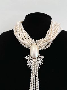 This one-of-a-kind dream necklace is created with multiple strands of freshwater pearls. The centerpiece is a unique, antique brooch made with 14k yellow gold and Mobé cultured pearls. This necklace is about 18" long, and the brooch measures at 3 1/2" x 2"