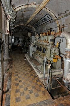 the inside of an old industrial building with pipes and machinery