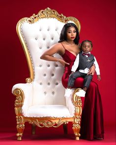 a woman sitting on top of a white chair next to a little boy in a red dress