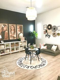 a living room filled with furniture and pictures hanging on the wall behind a round table