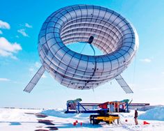 a large object is being lifted by a crane in the middle of snow covered ground