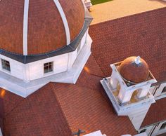 an aerial view of a large building with a dome on the top and two smaller buildings below